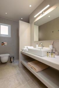 a bathroom with a sink and a toilet and a mirror at Villa Grotta in Kamarai +11 photos