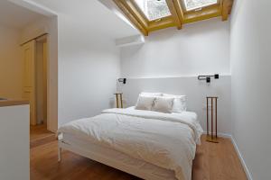 une chambre avec un lit avec des draps blancs et une fenêtre dans l'établissement Upper Town Rooms, à Zagreb