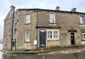 an old brick house with a blue door at No1 Chapel Street in Grassington