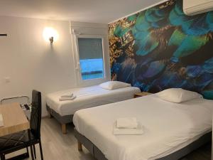 a room with two beds and a painting on the wall at Urban Style Arl HOTEL in Arles