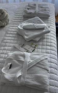 Una cama blanca con toallas blancas. en Fruške 202 studio apartman, en Vrdnik