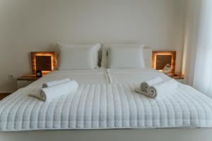 Una cama blanca con dos toallas. en Fruške 202 studio apartman, en Vrdnik