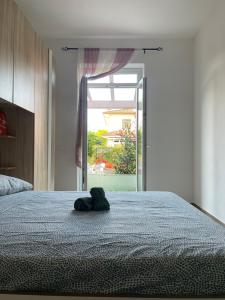 a stuffed animal is sitting on a bed at Garden Apartment in Marina di Carrara