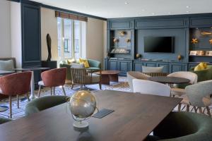 a room with a table and chairs and a tv at Hilton Antwerp Old Town in Antwerp