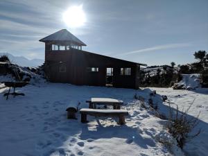 a picnic table in the snow in front of a building at Wild orchid trail cottages in Jhatingr