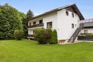 a white house with a green yard at Apartments Svetina in Bled