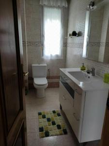 a bathroom with a white sink and a toilet at Tejas verdes in Argoños