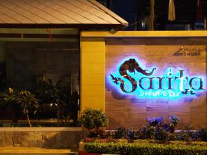 a neon sign on the side of a restaurant at Sarita Chalet & Spa Hotel - SHA Extra Plus in Jomtien Beach