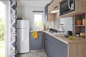 Grand-Village-PlageCamping Les Pins d'Oléron的配有白色冰箱和水槽的厨房