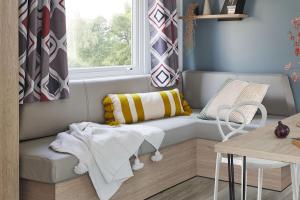 Grand-Village-PlageCamping Les Pins d'Oléron的小房间配有沙发和窗户