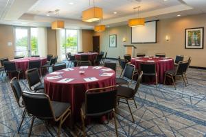 einen Konferenzraum mit Tischen, Stühlen und einem Bildschirm in der Unterkunft Holiday Inn Express Miami Airport-Blue Lagoon Area by IHG in Miami + 37 Fotos
