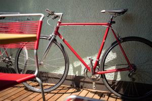a red bike parked next to a red chair at Kerenzer15 - The Studio in Mollis
