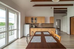 a kitchen with a wooden table and a large window at WDZYDZANIN in Wdzydze Tucholskie