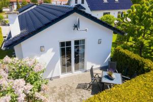 a view of a white house with a table and chairs at FH Mimi in Ostseebad Karlshagen