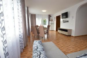 a living room with a table and chairs and a television at Casa Morena Tuzla in Tuzla