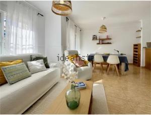 una sala de estar con un sofá y una mesa en Beautiful Chalet Adosado con piscina comunitaria, en Denia