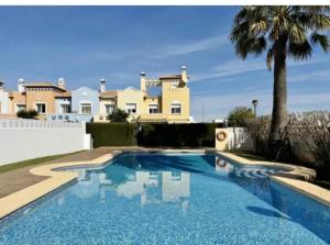 una piscina frente a una casa en Beautiful Chalet Adosado con piscina comunitaria, en Denia