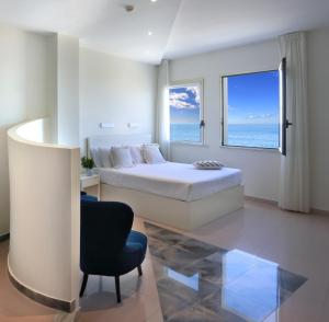 a bedroom with a bed and a large window at Piccadilly Rooms Restaurant and Beach in Santa Maria al Bagno