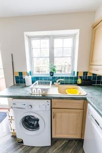 a kitchen with a washing machine and a sink at 2Bed Garden & Private Parking Near A19 - Perfect for Contractors in Pallion