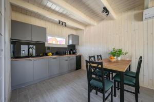 a kitchen with a wooden table and a dining room at RESORT za lasem II in Jarosławiec
