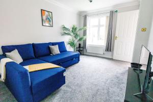 a blue couch in a living room with a window at 2Bed Garden & Private Parking Near A19 - Perfect for Contractors in Pallion