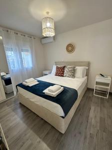 a bedroom with a large bed and a chandelier at Rouli's Houses by All About Paxos in Oziás