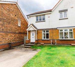 a brick house with a white door and a yard at 2Bed Garden & Private Parking Near A19 - Perfect for Contractors in Pallion