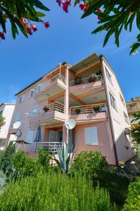 un edificio de apartamentos con balcones y plantas en Apartman Kiki, en Rabac