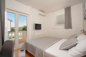 a white bedroom with a bed and a window at Pansion Villa Bok in Novalja +39 photos