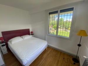 a bedroom with a white bed and a window at Appartement dans Villa in Ouistreham