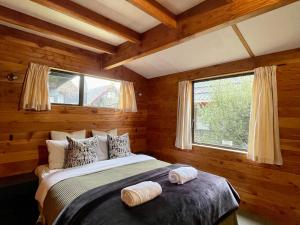 a bedroom with a bed with two towels on it at Snow Chalet - Ohakune Chalet in Ohakune