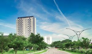 a tall white building on the side of a road at Pleasant Tamansari Prospero Studio Apartment in Sidoarjo by Le Ciel Hospitality in Sidoarjo