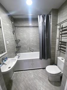 a bathroom with a tub and a toilet and a sink at Komrat Apartments in Almaty +10 photos