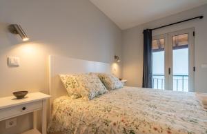 a bedroom with a bed with a large window at Casas das Hortas, Apartamento Vista Mar in Seixal