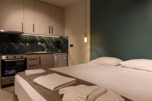 a bedroom with two beds and a sink and a kitchen at Dimitra's studio in Preveza