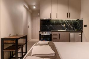 a kitchen with white cabinets and a table and a sink at Dimitra's studio in Preveza