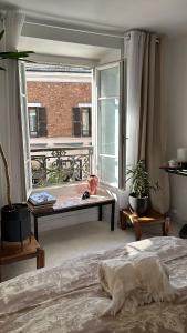 a bedroom with a bed and a large window at Agréable maison de village in Dampierre