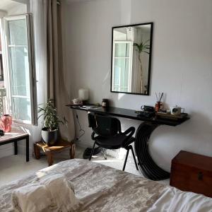 a bedroom with a desk with a mirror and a chair at Agréable maison de village in Dampierre