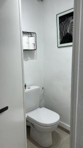 a white bathroom with a toilet and a zebra picture at Agréable maison de village in Dampierre +5 photos