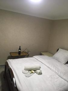 a bedroom with a white bed with a bottle of wine at Eddy in Borjomi