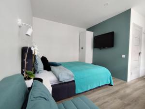 a bedroom with a bed and a couch at Modern Courtyard Condo in Liepāja