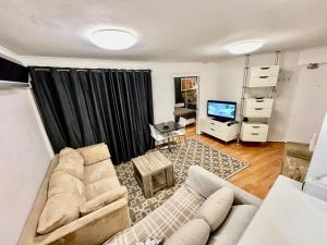 a living room with a couch and a tv at Kingsleigh Apartments Sydney in Sydney