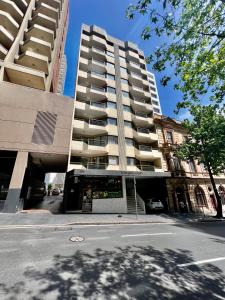 a tall apartment building with a bus stop in front of it at Kingsleigh Apartments Sydney in Sydney