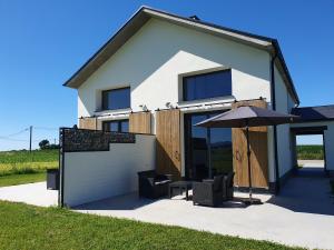a house with an umbrella and a table and chairs at Apartamentos Islas Pantorgas in Tapia de Casariego