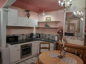 a kitchen with white cabinets and a table in it at Studio Magenta in Vinça