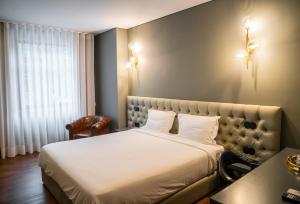 a bedroom with a bed and a desk and a window at Santo Thyrso Hotel in Santo Tirso