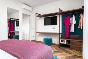 a bedroom with a purple bed and a tv at Futura Funky House - De Vivo Realty Sorrento in Sorrento