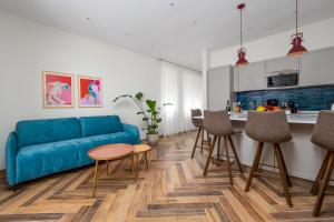 a living room with a blue couch and a kitchen at Futura Funky House - De Vivo Realty Sorrento in Sorrento