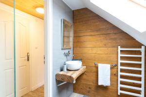 a bathroom with a sink on a wooden wall at Natura vendégház in Abaújvár +60 photos