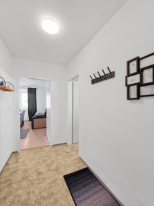 a living room with a white wall and a bedroom at Stockerau Family Haven for 4 in Stockerau